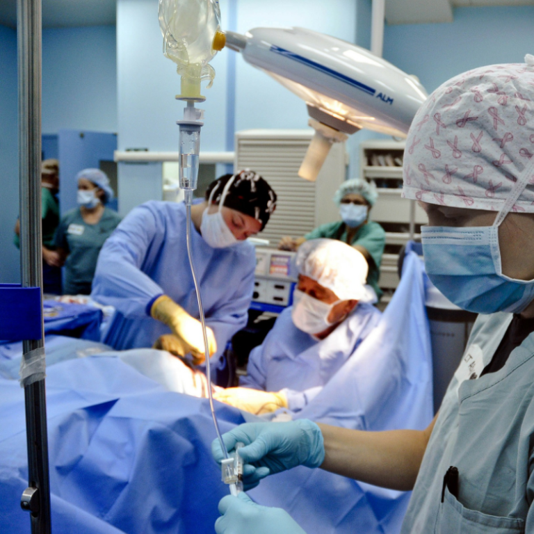 Compass Associates - Candidate Services - medical surgeons in theatre carrying out an operation on a patient