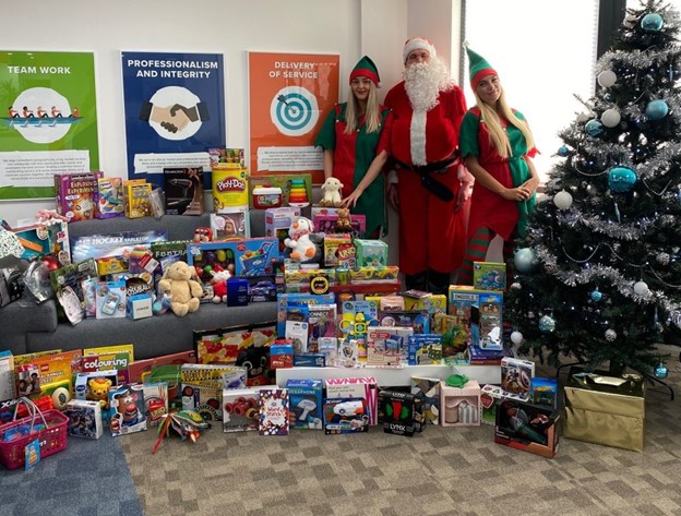 Christmas toy donations from Compass Associates along with christmas decorations and staff dressed up as elves and Father Christmas
