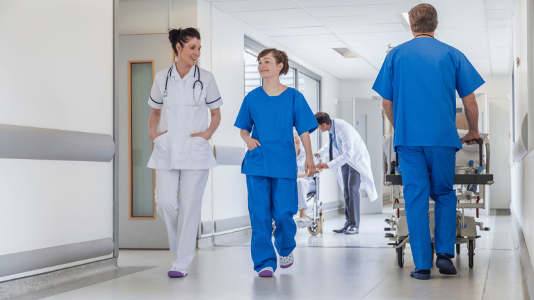 Compass Associates - International Nurses Day - Nurses and Doctors walking down hospital corridor