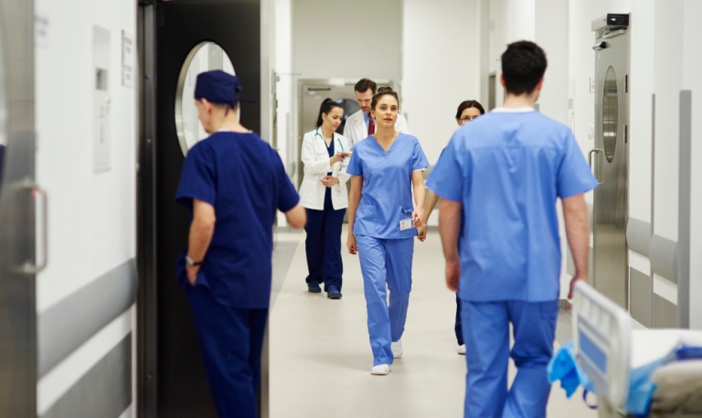 Compass Associates - Client Services - Volume Capacity - A candid photo of medical professionals walking through a hospital corridor